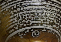 Surface émaillée selon la technique du « grès au sel », dont la particularité est la concentration des gouttelettes d'émail en surface de la céramique.
