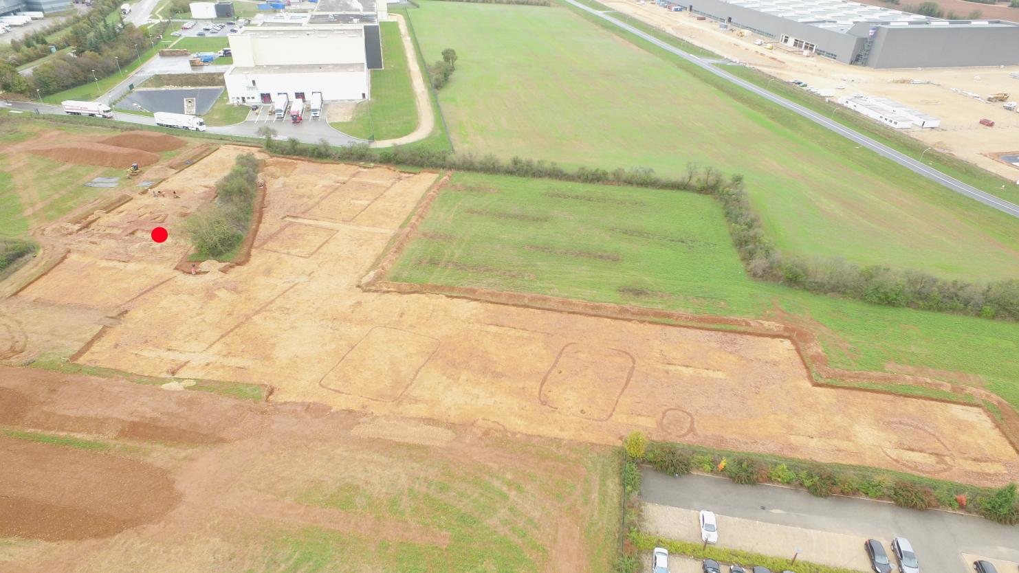 Fouille de Saint-Vulbas (Ain). Vue aérienne du chantier, en cours de fouille (partie claire en L). Le point rouge correspond au lieu de découverte du trésor monétaire.