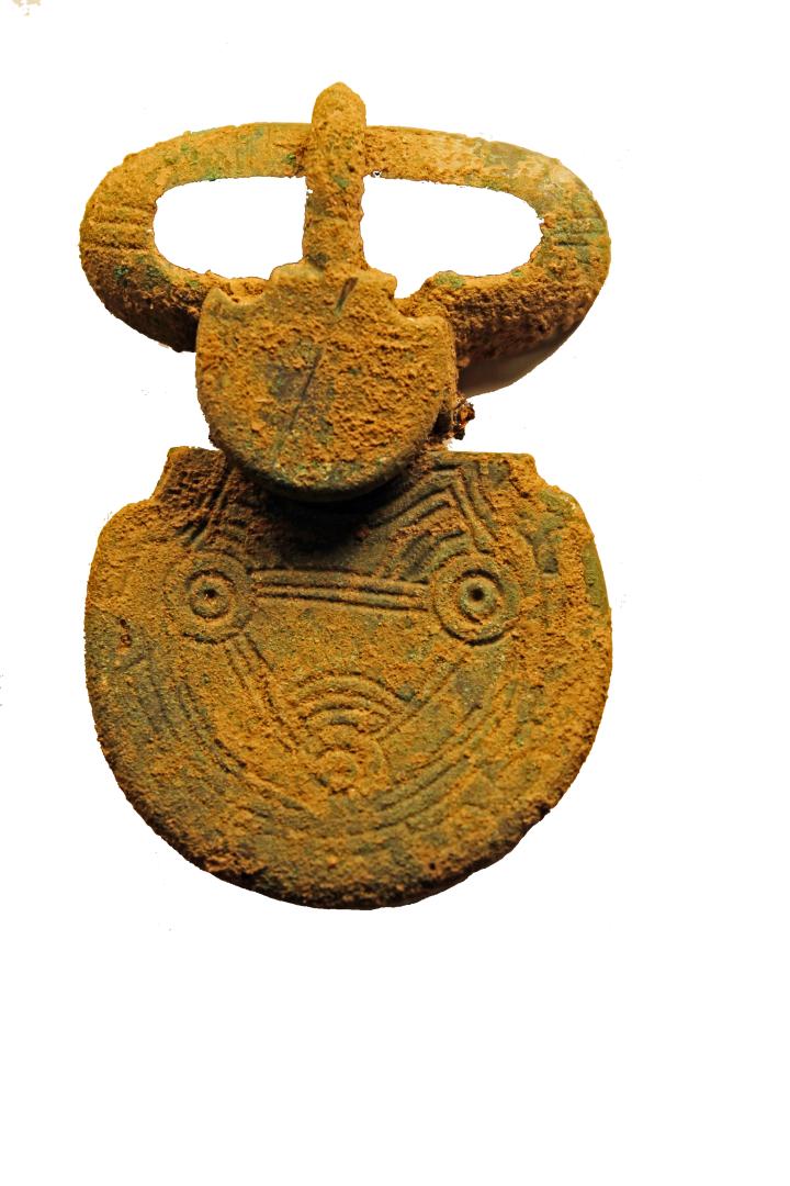 La plaque-boucle en alliage cuivreux trouvée dans une sépulture perturbée appartenant au groupe funéraire sud-est, datée par radiocarbone de la fin du VIe s. 