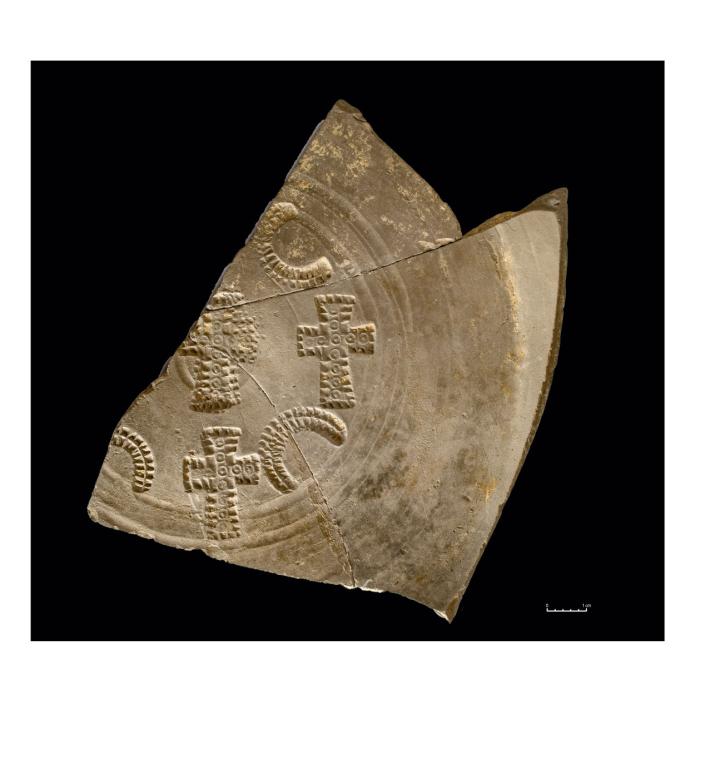 Un fragment de plat en céramique dérivée de sigillée paléochrétienne ornée de poinçons cruciformes, témoignant jusque dans le décor des objets du quotidien de l’influence du christianisme. 