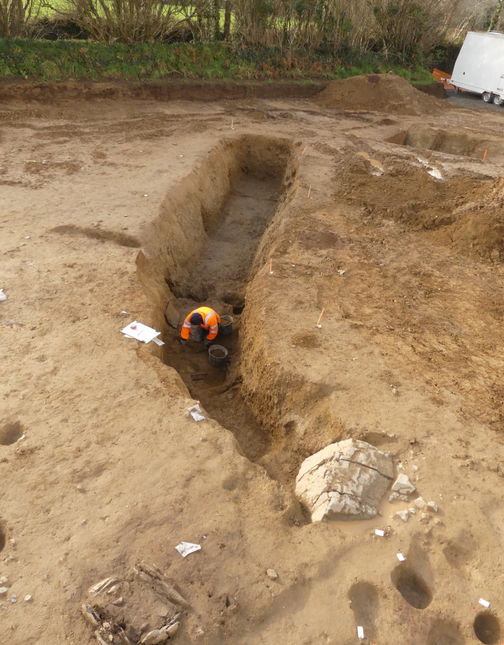Cave du premier âge du Fer, l'accès se fait par un escalier en partie condamné par le gros bloc de quartz au premier plan.