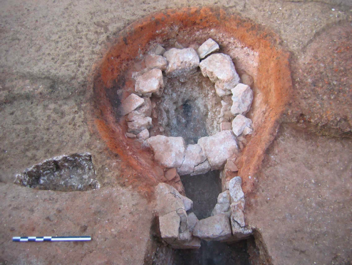 Vue d'une chambre de cuisson constituée d'un assemblage de blocs et de traverses qui occultent partiellement le canal de chauffe de façon à laisser passer la chaleur tout en supportant la charge à calciner. Les pierres sont issues d'un édifice antique monumental démantelé.