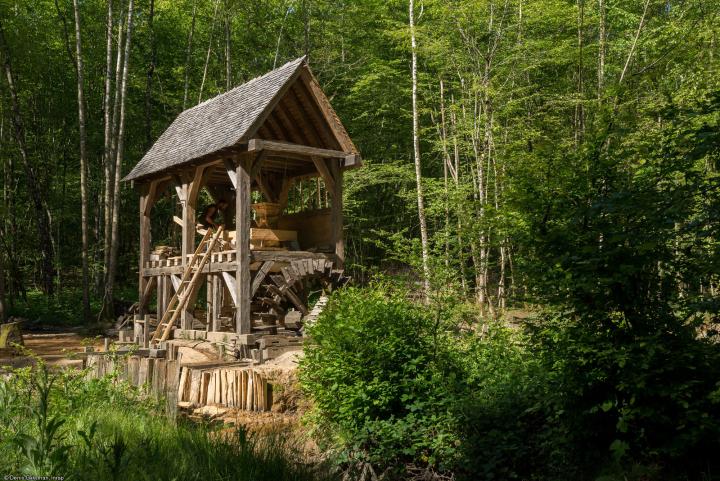 Moulin reconstitué (vue de l'est) avec la roue au premier niveau et la chambre des meules au second, Guédelon (Yonne), 2014.Cette reconstitution s’appuie sur les vestiges de deux moulins hydrauliques mis au jour en 2008 à Thervay (Jura), l’un de la périod