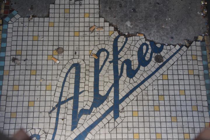 Mosaïque de seuil très dégradée, dernier vestige de la boutique Chapeaux Alfred, rue de la Loge à Montpellier.