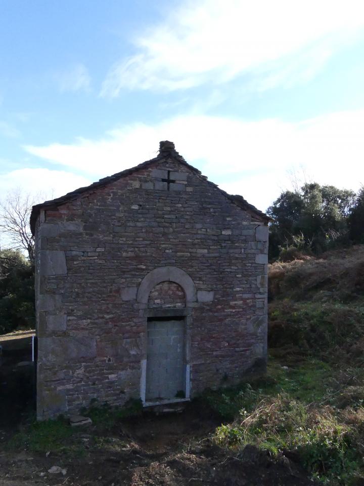 Portail occidental de l'église avec sa croix ajourée visible au sommet du fronton, qui est caractéristique de l'architecture romane insulaire.