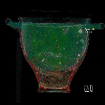 Analyse tomodensitométrique d’un skypos (vase) et de son contenu découverts dans la chambre funéraire. La restitution en volume permet de faire apparaître une coupelle au sein de celui-ci. Les couleurs sont artificielles et ont été définies en fonction de l’absorption des rayons X par les types de matériaux. Analyse réalisée en post-fouille par la société BCRX.