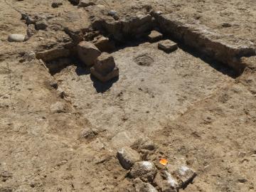 Vue de la base de l’hypocauste constitué d’un fond revêtu de mortier de tuileau et ayant conservé quelques pilettes en grès ou en briques. 