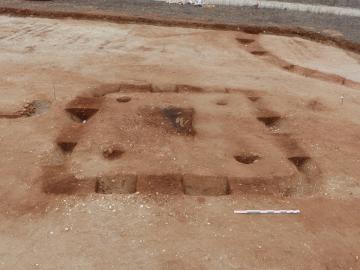 Vue générale du monument funéraire de la fin du Premier âge du Fer, en cours de fouille avec un enclos circulaire en arrière-plan. 