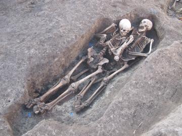 Vue de sépultures rupestres d’époque médiévale superposées et contenant les squelettes de trois femmes d’âge mûr à âgé.