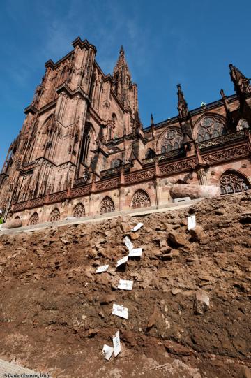 Fouille aux abords de la cathédrale de Strasbourg (Bas-Rhin), 2012. À l'arrière plan la cathédrale ; au premier plan, les niveaux archéologiques du chantier de construction de cette dernière, édifiée entre le XIIe et le XVe s. On retrouve dans ces niveau Fouille aux abords de la cathédrale de Strasbourg (Bas-Rhin), 2012. À l'arrière plan la cathédrale ; au premier plan, les niveaux archéologiques du chantier de construction de cette dernière, édifiée entre le XIIe et le XVe s. On retrouve dans ces niveau