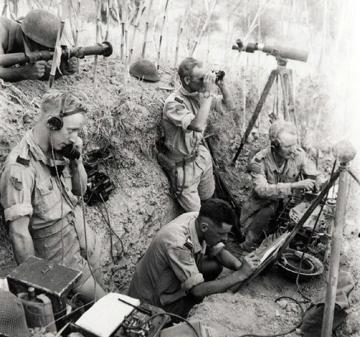 Tranchée d’observation de l’artillerie canadienne (Potenza, Italie, 24 septembre 1943), offrant des caractéristiques similaires à celle de Blainville-sur-Orne. Le chef de pièce est entouré d’un observateur au télémètre, allongé hors de la tranchée, d’un pointeur reportant les coordonnées de tir sur carte, et de deux transmetteurs. Deux hommes accroupis sont installés sur la banquette qui borde la tranchée du côté de l’ennemi.