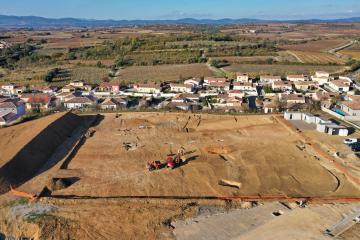 Au second plan se devine l'Oppidum de Montfo qui fait face à la zone de fouille tandis qu'au dernier plan s'élève l'extrémité sud du Massif central formé par la Montagne noire.