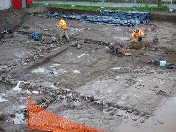 Au premier plan, fondations en galets des murs du second bâtiment en partie immergé sous les eaux de pluie. 