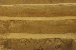 Vue des six premiers mètres de sédiment au nord du gisement. A la base, les sols humifères gris du niveau acheuléen datant d’un peu plus de 300 000 ans. 