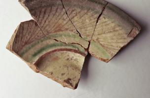 Fragment d'assiette vernissée datant de l'Époque moderne découverte à Montbartier (Tarn-et-Garonne) en 2023. Plusieurs petites aires d’ensilage du Moyen Âge (XIe-XIIe siècles) et une occupation moderne (début XVIIIe siècle) y ont été mis au jour. 