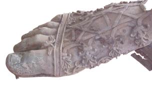 Pied droit d’une statue colossale en bronze découvert sur le sol d’une cour attenante à une domus, début du IIe&nbsp;s. de notre ère,&nbsp;Clermont-Ferrand (Puy-de-Dôme), 2007.Long de plus de 60 cm, le pied est chaussé d’une botte lacée richement décorée 
