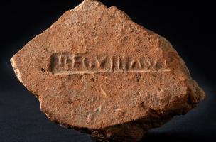 Fragment d'une tuile ou d'une brique romaine marquée par l'estampille de la VIIIe légion Auguste ("LEG VIII AUG"), place du Château, Strasbourg (Bas-Rhin), 2012.  La légion s'installe dans l'antique Argentorate dans les années 90 de notre ère. Ses 6000 ho