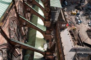 Vue prise depuis la flèche de la cathédrale de Strasbourg (Bas-Rhin), 2012.  Au premier plan les arc-boutants de la nef gothique ; au second plan l'opération archéologique mettant au jour les niveaux du chantier de construction de la cathédrale, érigée en