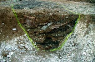 Coupe stratigraphique d'une tranchée de la Grande Guerre ayant livré les rebuts d'un atelier d'artisanat de tranchée sur la ZAC Actiparc d'Arras (Pas-de-Calais), 2002.   Photo publiée dans l'ouvrage&nbsp;L'archéologie de la Grande Guerre, Y. Desfossés, A.