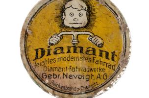Emblème publicitaire de vélo de la marque "Diamant". Ce vélo est fabriqué dans l'usine de Chemnitz (Allemagne) par les frères Nevoigt depuis 1885. Découvert en surface d'une fosse allemande datant de la Grande Guerre à Saint-Etienne-sur-Suippe (Marne), 20