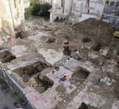 Vestiges des maisons modernes et contemporaines après leur démolition. La fouille de leurs fondations et de leurs sols successifs a montré leur mise en place et leur évolution entre le XVIe et le XIXe siècle. En bas à gauche, la rue du Palais de Justice. En haut à droite, la Place Catalogne.