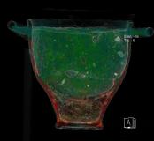 Analyse tomodensitométrique d’un skypos (vase) et de son contenu découverts dans la chambre funéraire. La restitution en volume permet de faire apparaître une coupelle au sein de celui-ci. Les couleurs sont artificielles et ont été définies en fonction de l’absorption des rayons X par les types de matériaux. Analyse réalisée en post-fouille par la société BCRX.