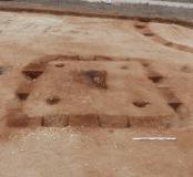 Vue générale du monument funéraire de la fin du Premier âge du Fer, en cours de fouille avec un enclos circulaire en arrière-plan. 