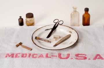 Matériel médical de l'US Army : flacons pharmaceutiques, pot de vaseline, bassin, paire de ciseaux, seringue, bistouri, ampoules de solution injectable, rasoir "Penn" et serviette du Medical Department USA. Provenant de l'ancien hôpital militaire américai