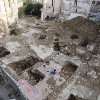 Vestiges des maisons modernes et contemporaines après leur démolition. La fouille de leurs fondations et de leurs sols successifs a montré leur mise en place et leur évolution entre le XVIe et le XIXe siècle. En bas à gauche, la rue du Palais de Justice. En haut à droite, la Place Catalogne.