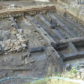 Mur de terrassement (au fond) et aménagement de quai en caissons de poutres, une fois enlevées les dalles de schiste qui stabilisaient l'ensemble de la structure. 