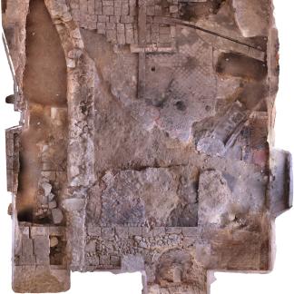 Cuisine médiévale dans l'aile est avec , en bas de l'image, le mur médiéval arasé et le pavage en terre cuite ; à droite la cheminée en tuileaux et en arrière-plan le système de boucherie ; à gauche, mur d'un couloir du XVIe siècle.