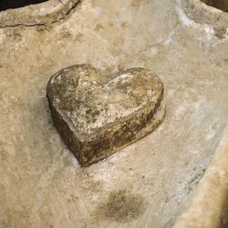 Vue de détail du coeur en plomb posé sur l’un des sarcophages. La présence de cette relique signe en général une pratique d’embaumement, un rituel funéraire réservé aux élites (fouille de Flers, 2014).