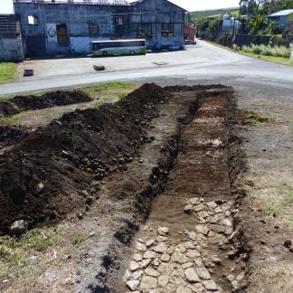 Le sol de pavés du XIXe siècle, en arrière-plan l’usine sucrière et le four à chaux, transformé en oratoire.
