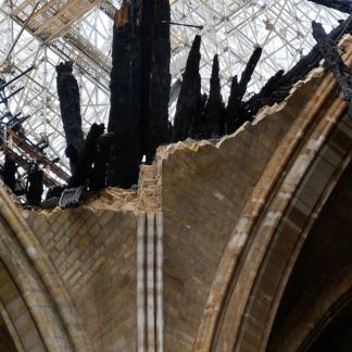 Détail de la voûte de la croisée du transept effondrée avec morceaux de charpente de la flèche carbonisés et en équilibre, le 26 avril 2019
